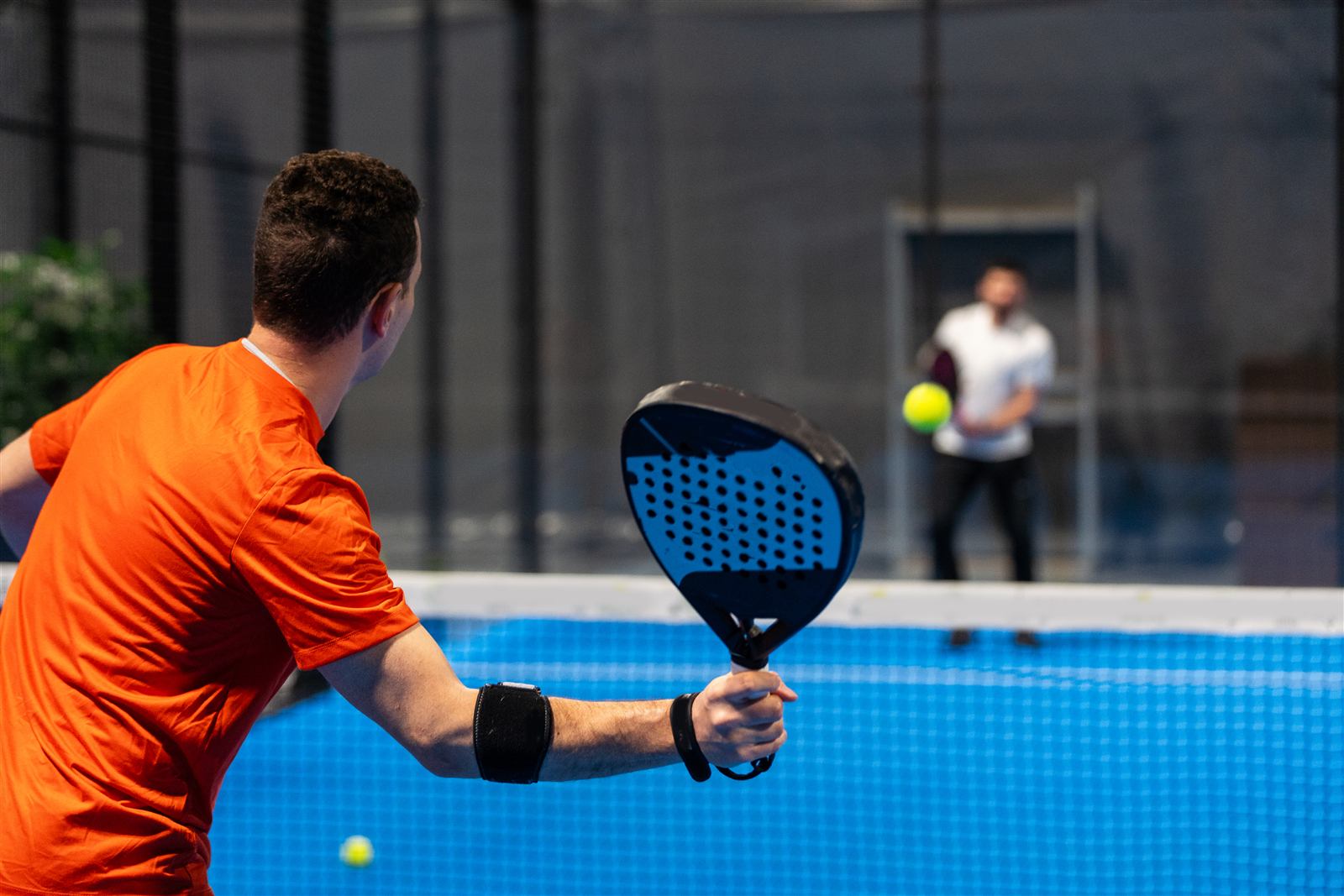 Padner hitting a forehand on a blue court